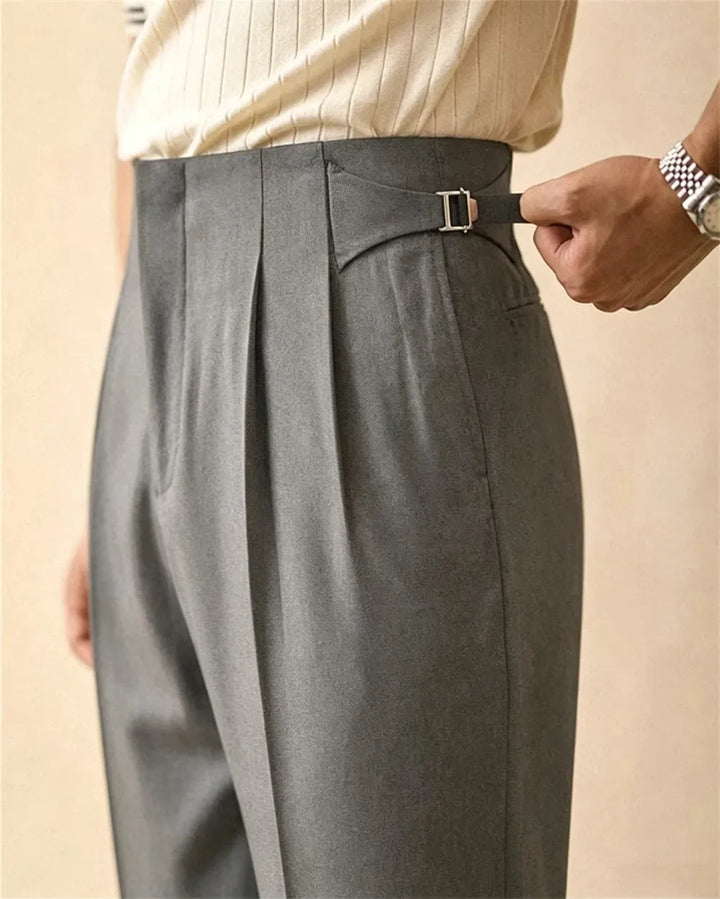 Close up of grey trousers with side buckle detail