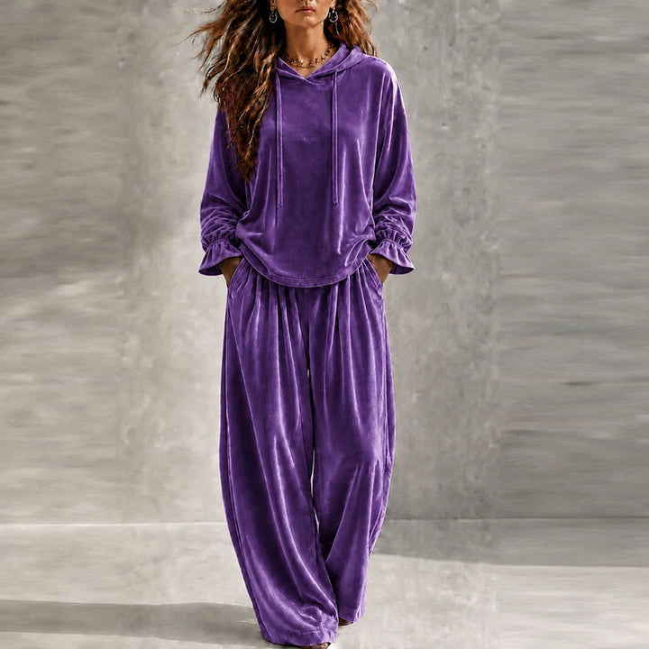 Woman wearing purple velvet hooded tracksuit with wide leg pants