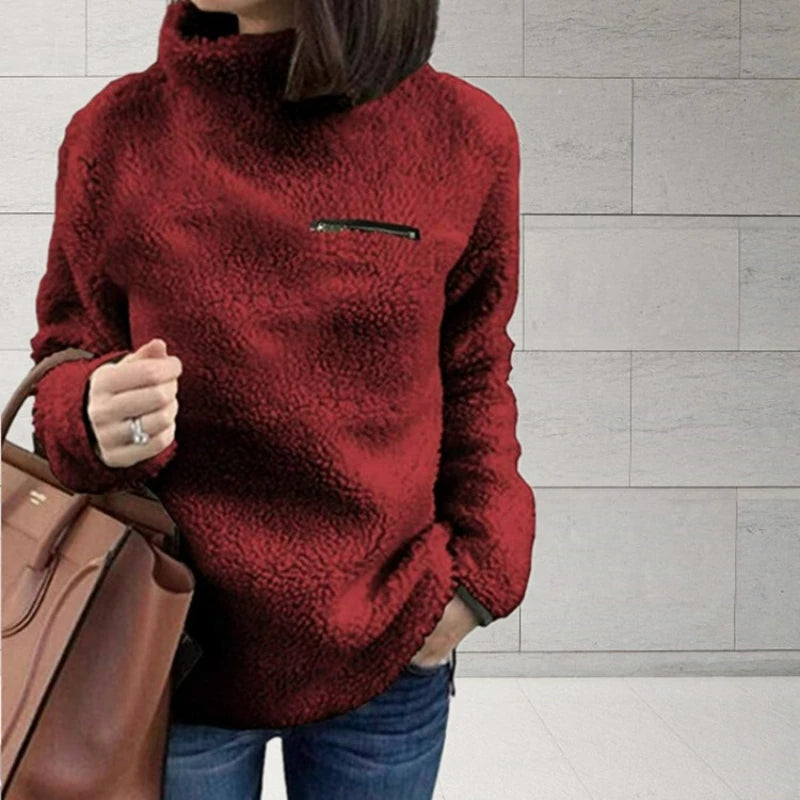 Woman wearing wine red sherpa turtleneck pullover with zip chest pocket