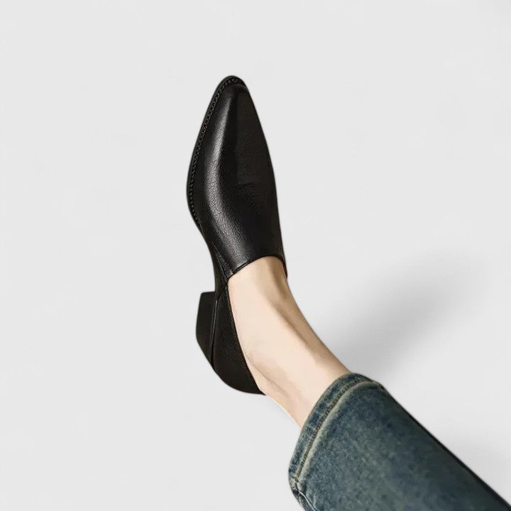 Black pointed-toe loafer shown from above on foot