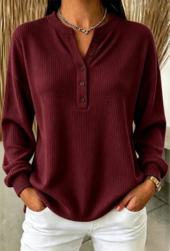 Woman wearing burgundy ribbed knit henley top with button placket
