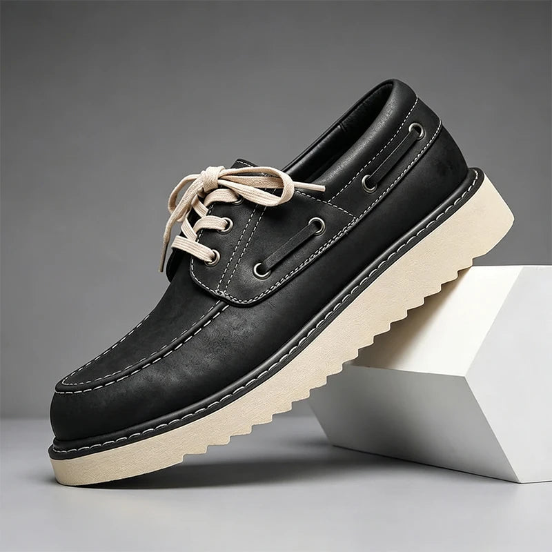 Black leather boat shoe angled view on gray background