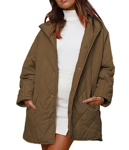 Woman wearing khaki diamond quilted hooded jacket over white sweater dress