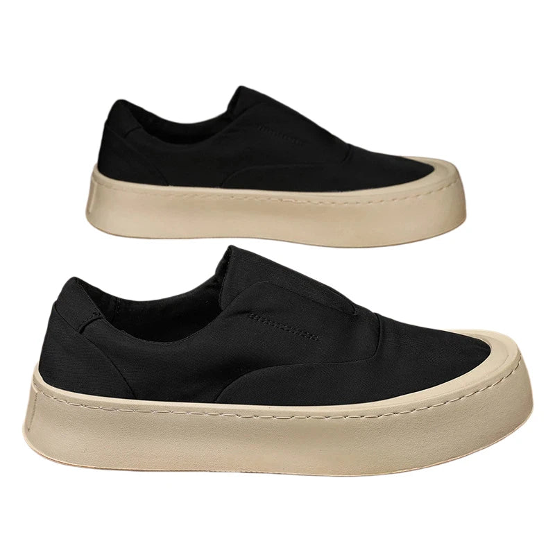 Black canvas slip-on sneakers pair on white background