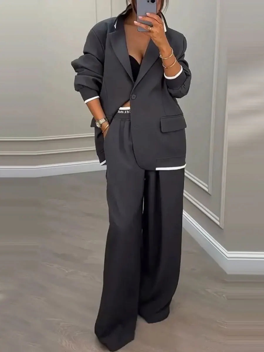 Dark grey notched lapel blazer and wide leg trouser suit, front view