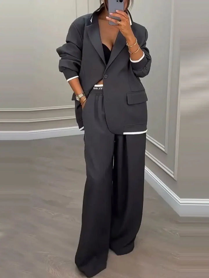 Dark grey notched lapel blazer and wide leg trouser suit, front view