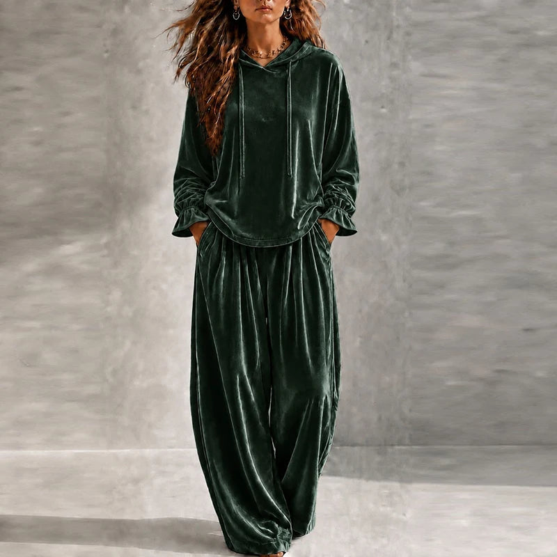 Woman wearing green velvet hooded tracksuit with wide leg pants