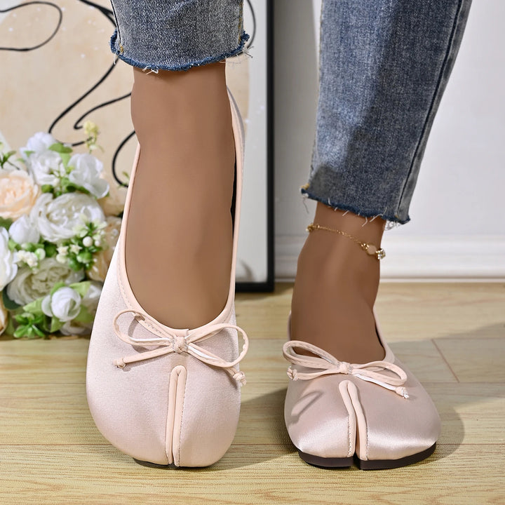 Model wearing beige tabi ballet flats with bow detail