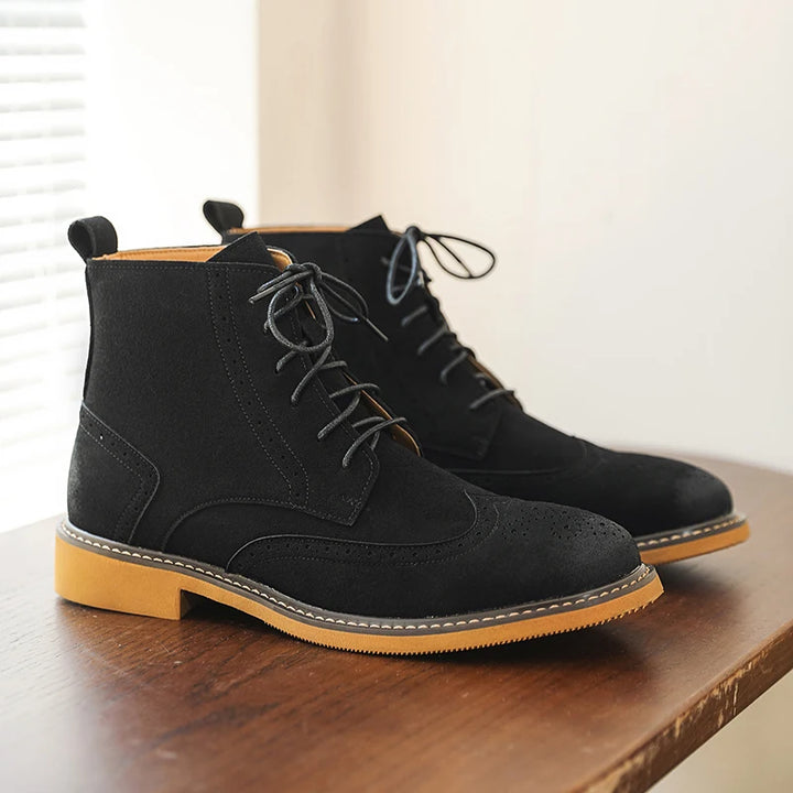 Black wingtip brogue ankle boots on wood table with contrast sole
