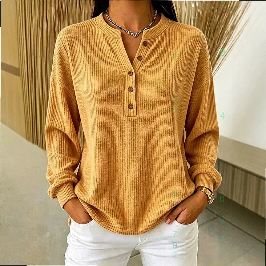 Woman wearing yellow ribbed knit henley top with button placket