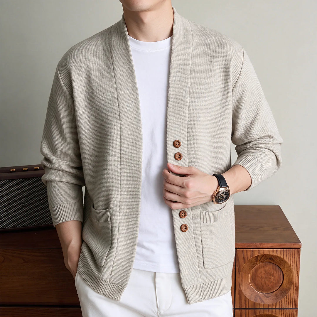 Man wearing beige knit shawl collar cardigan with patch pockets