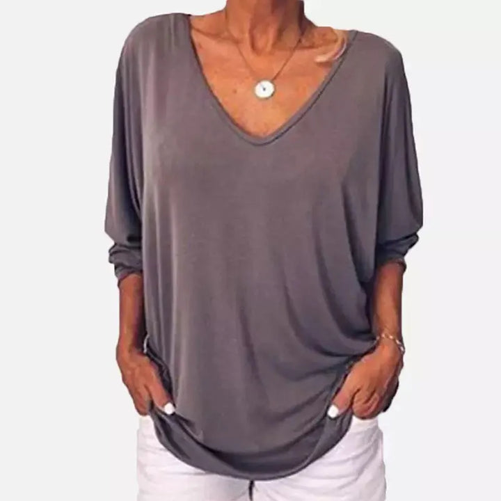 Woman wearing grey V-neck three-quarter sleeve top, front view
