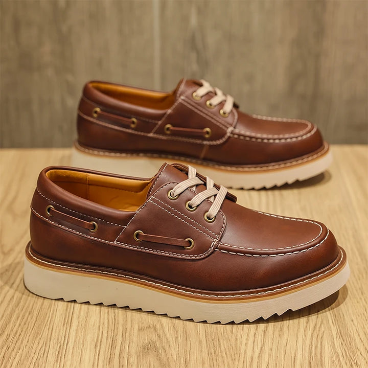 Brown leather boat shoes side and front view on wood surface