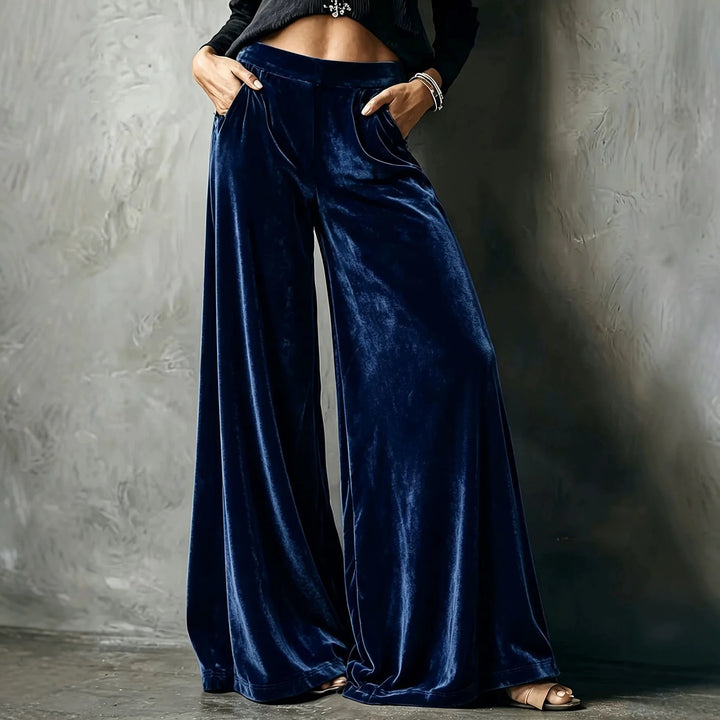 Woman wearing dark blue velvet wide leg pants with hands in pockets