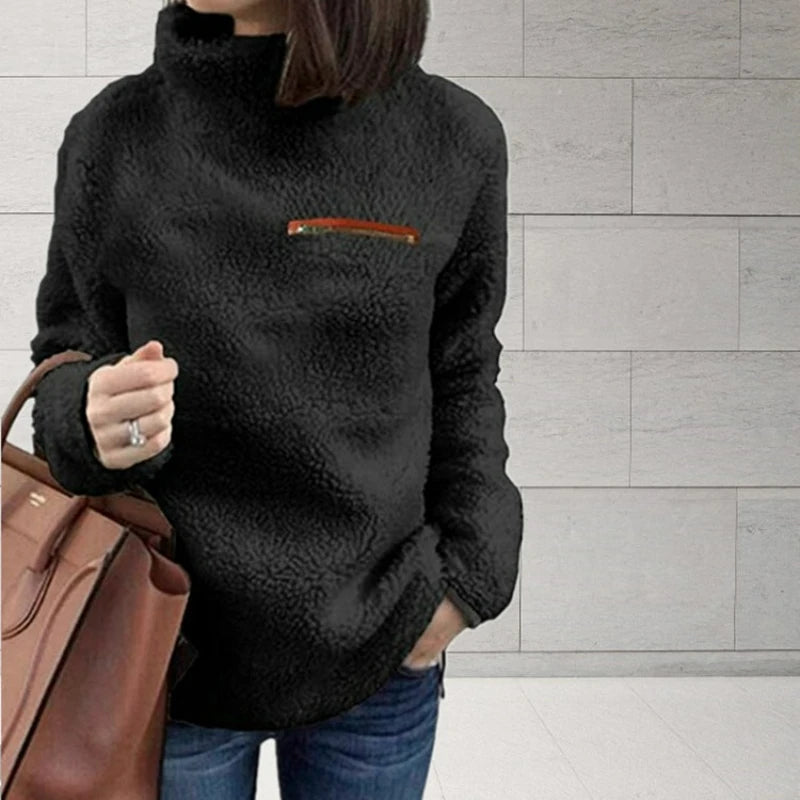 Woman wearing black sherpa turtleneck pullover with zip chest pocket
