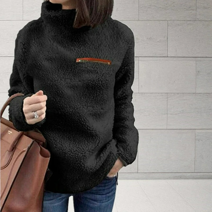 Woman wearing black sherpa turtleneck pullover with zip chest pocket
