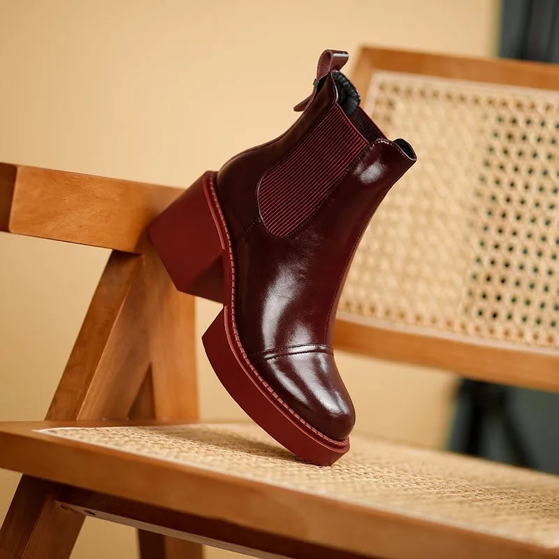 Wine red Chelsea boot with platform heel propped on chair