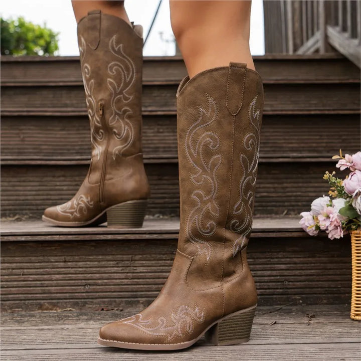 Brown embroidered cowboy boots on model standing on steps
