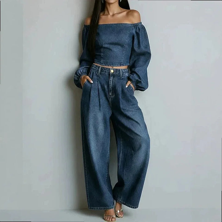 Woman wearing dark blue denim off-shoulder crop top and wide leg pants set, front view
