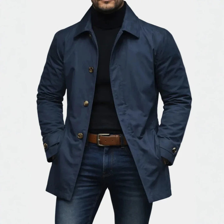 Man wearing navy mac-style trench coat with point collar and belt