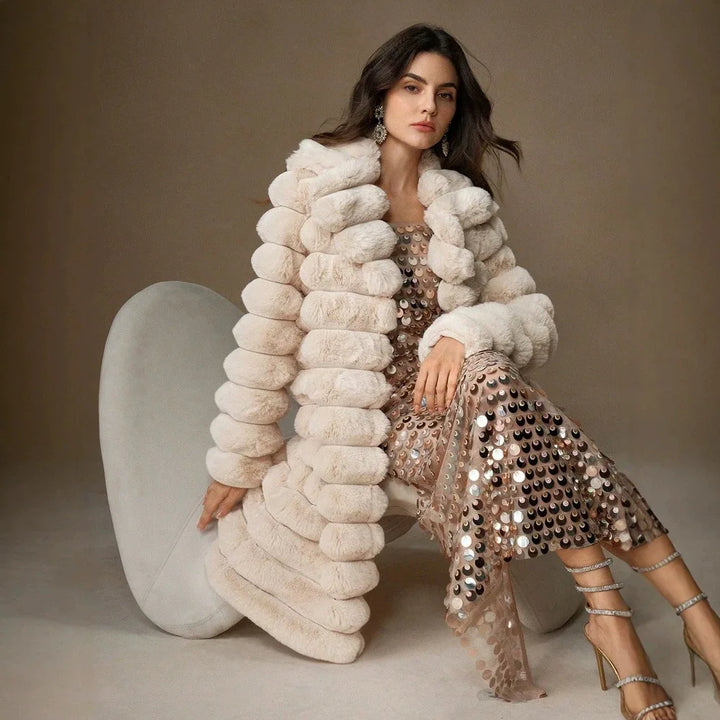 Seated model in light brown faux fur coat showing textured sleeve detail
