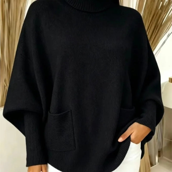 Woman wearing black turtleneck batwing sweater with front pocket
