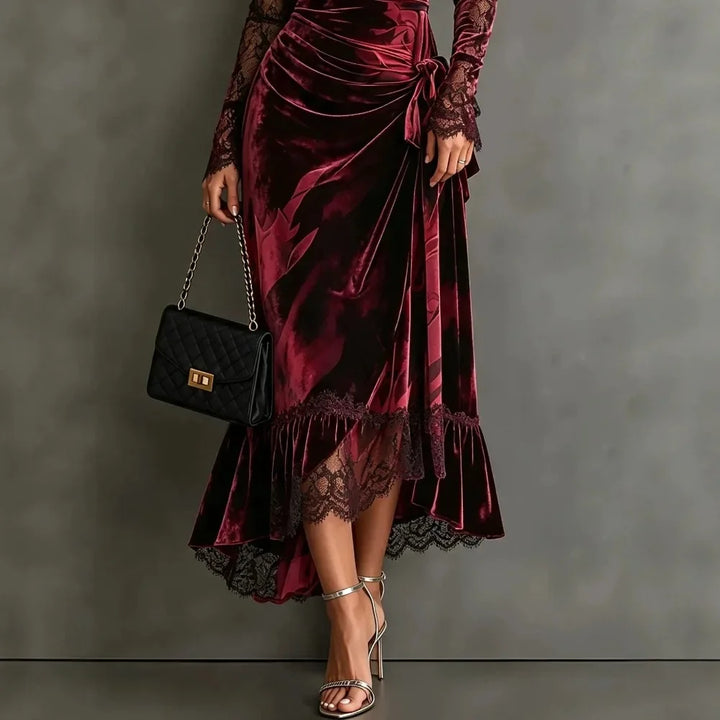 Close-up of dark red velvet dress tie waist and asymmetric fishtail hem