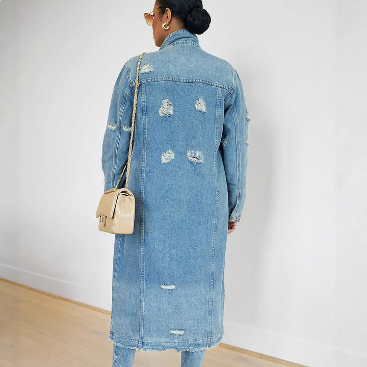 Back view of distressed denim trench coat showing rip details