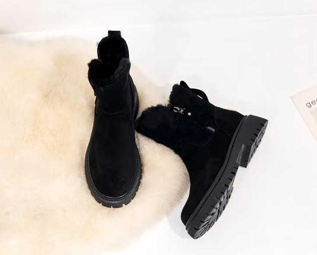 Pair of black chunky ankle boots on faux fur rug