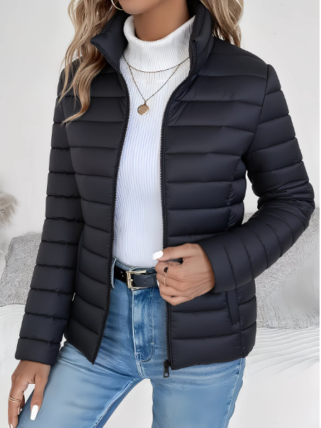 Woman wearing black quilted puffer jacket with stand collar, zipped open