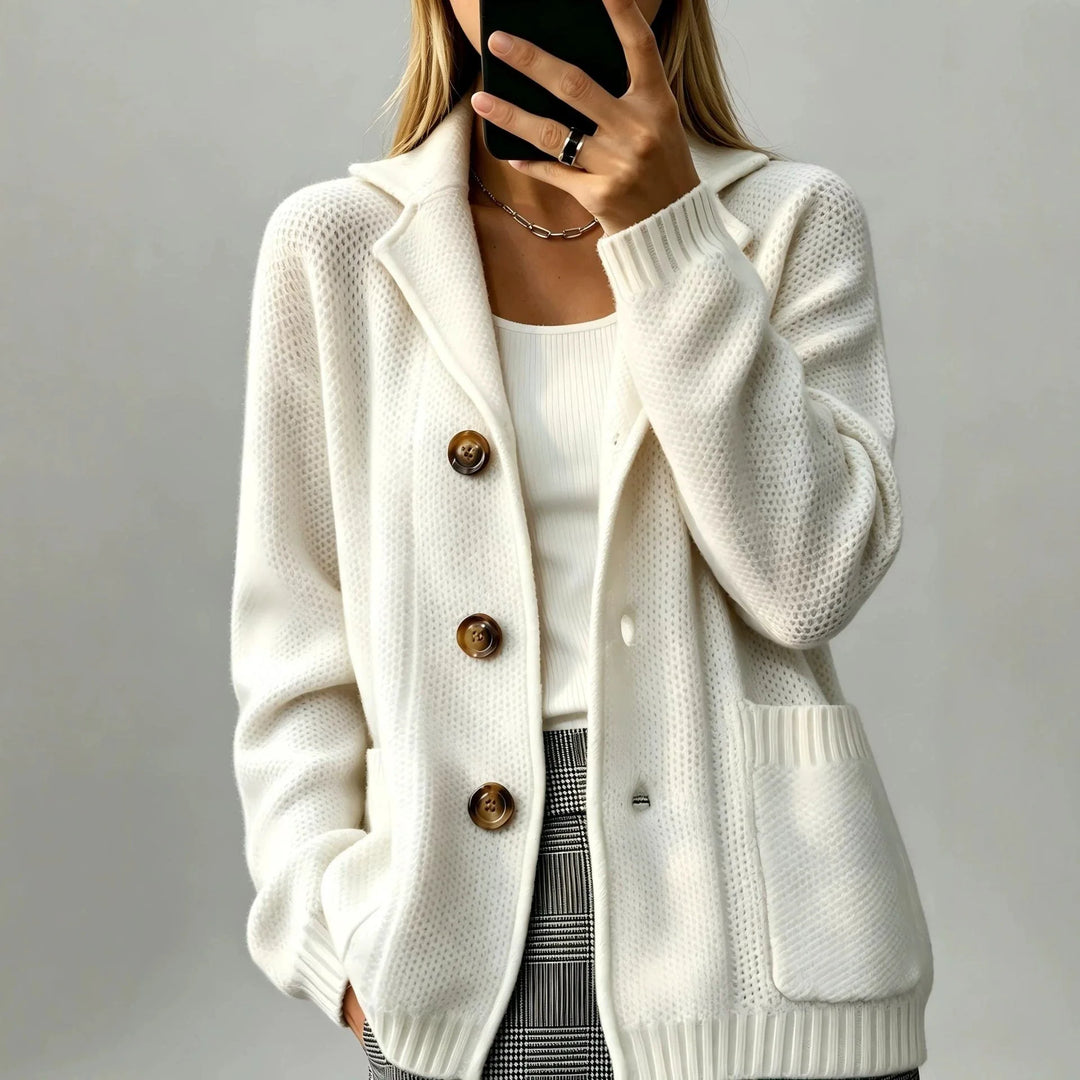 Woman wearing creamy-white waffle knit cardigan with notched lapel and tortoiseshell buttons