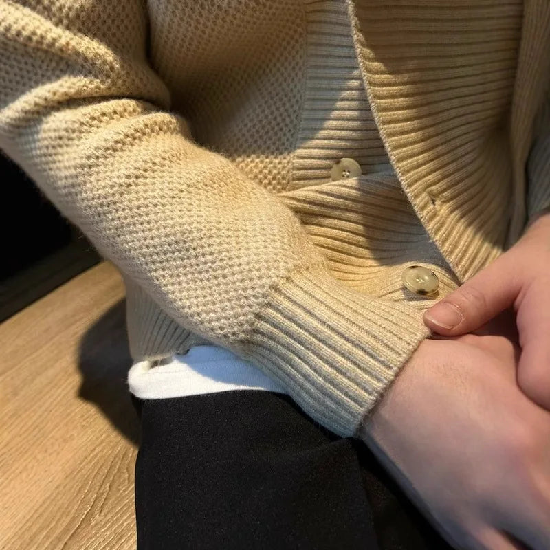 Close up of khaki cardigan button and ribbed cuff detail