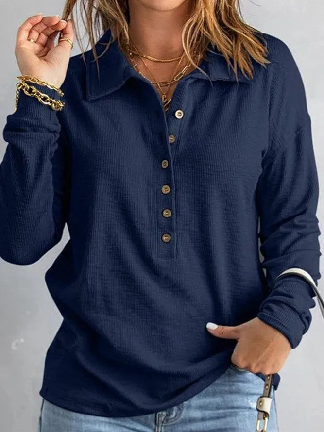 Woman wearing navy blue ribbed knit henley top with button placket