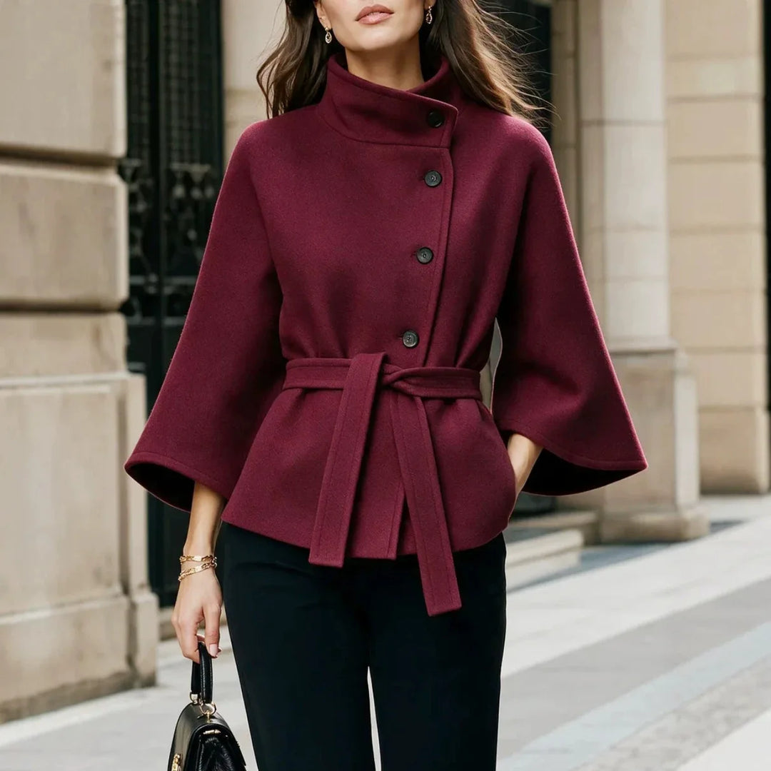 Woman wearing burgundy belted cape coat with stand collar