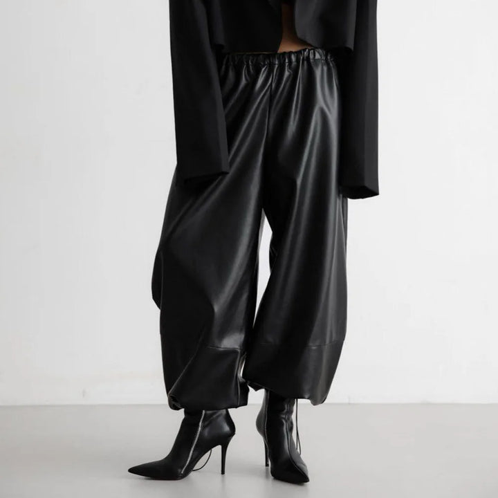 Front view of black faux leather lantern pants with elastic waistband