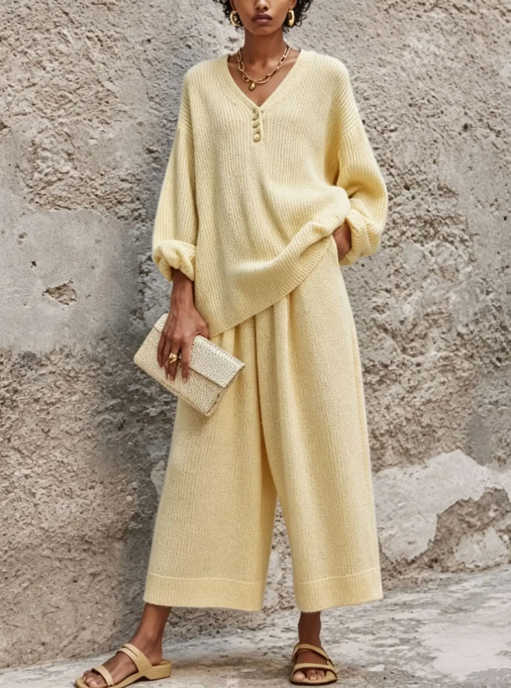 Close up of light yellow knit sweater with button V-neck detail