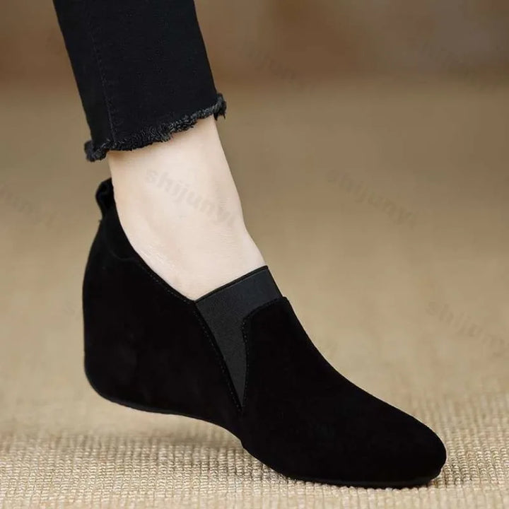 Black suede wedge bootie side view worn with black pants