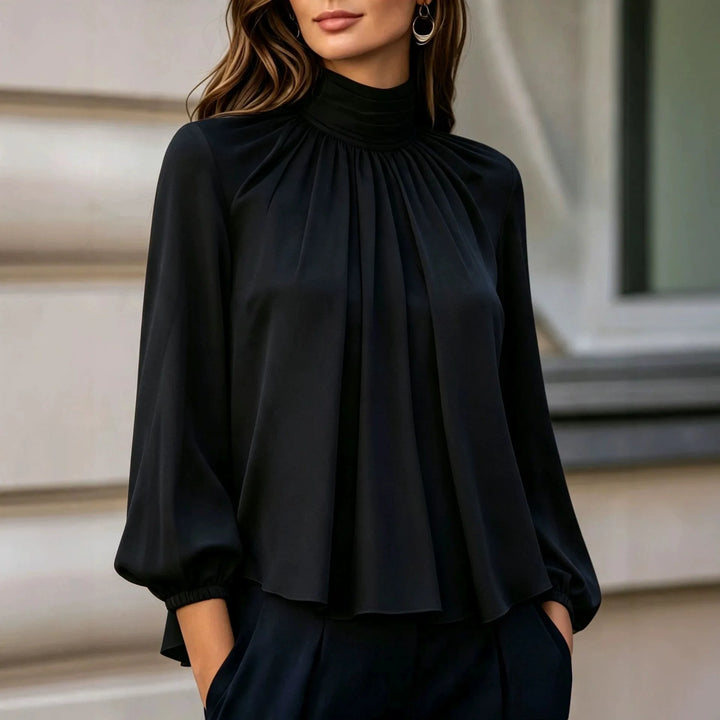 Woman wearing black pleated mock neck blouse with bishop sleeves