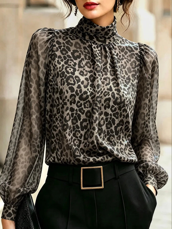 Woman wearing grey leopard print blouse with high mock neck and sheer lantern sleeves