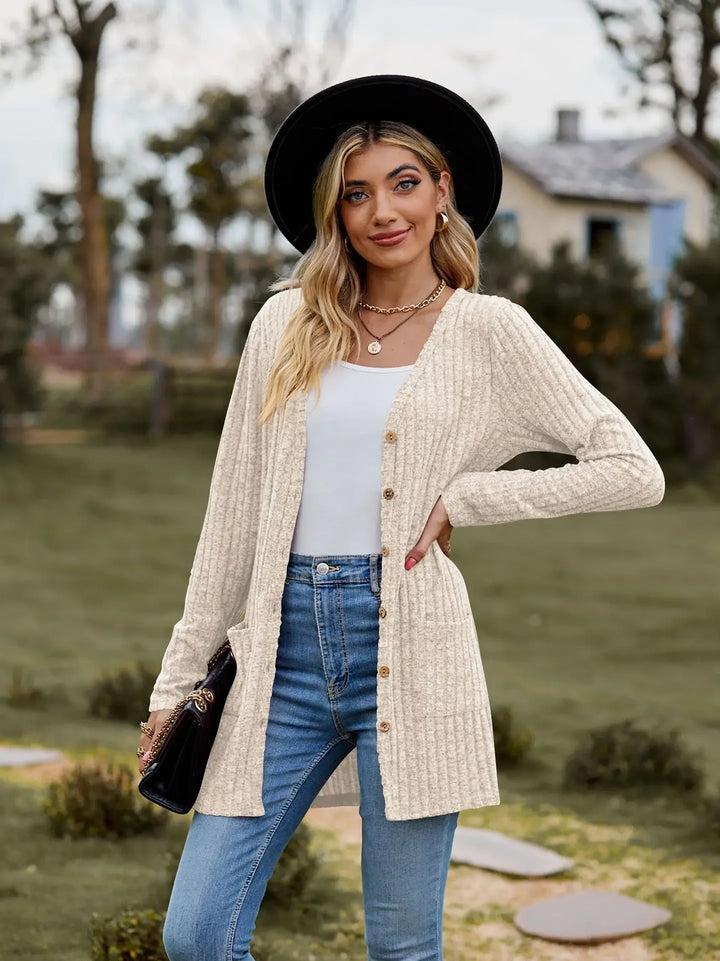 Woman in black hat wearing beige ribbed knit cardigan