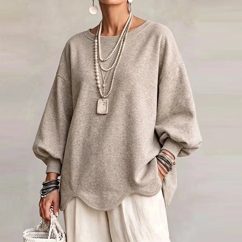 Woman wearing beige oversized sweatshirt with wavy hem