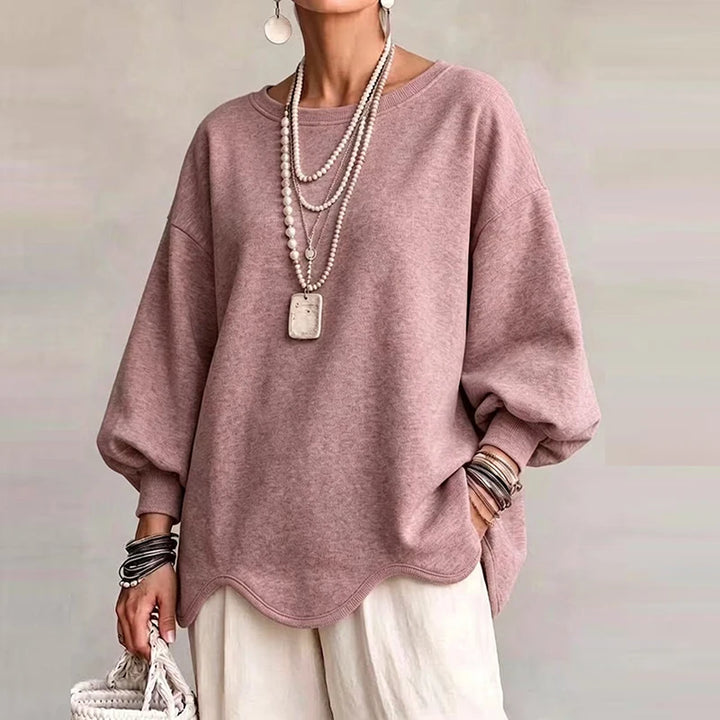 Woman wearing dusty pink oversized sweatshirt with wavy hem