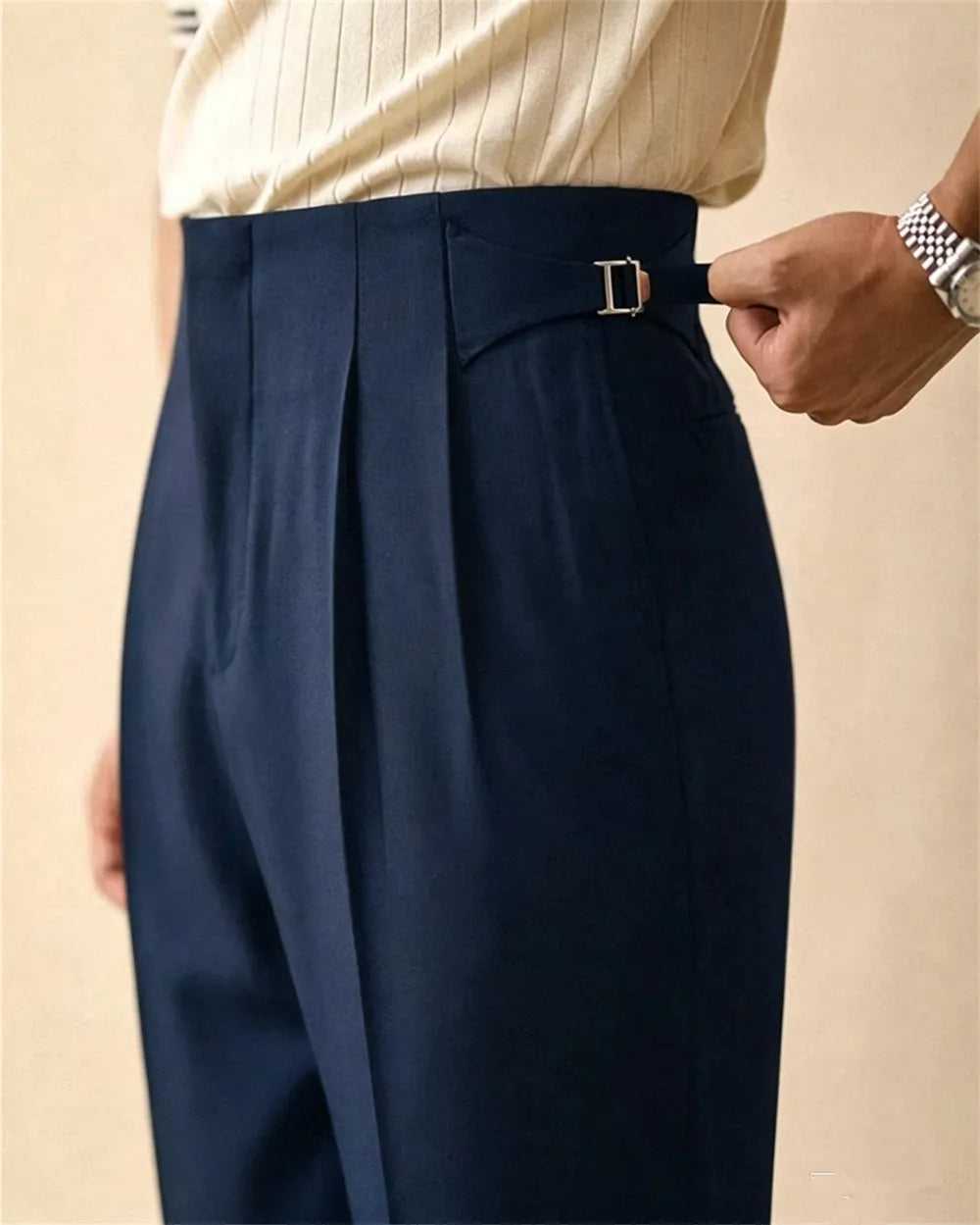 Close up of navy blue trousers with side tab buckle