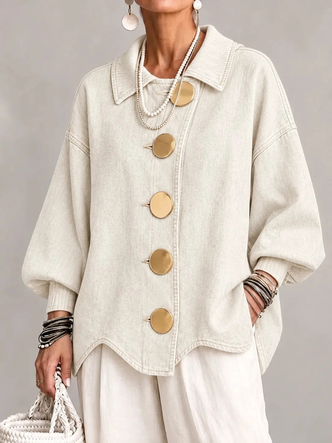 Woman wearing beige denim jacket with large gold buttons, front view