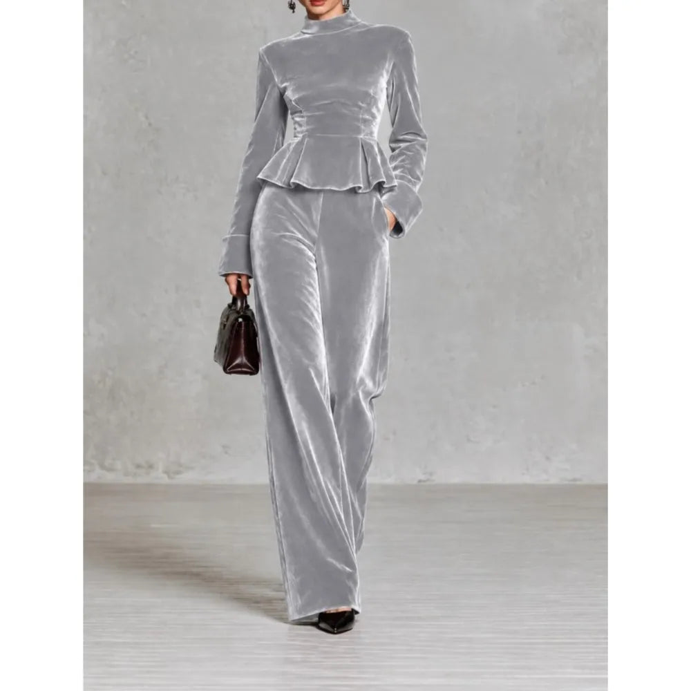 Woman wearing light grey velvet peplum top and wide leg pants set, front view
