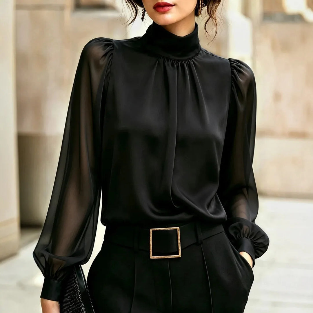 Woman wearing black blouse with high mock neck and sheer lantern sleeves