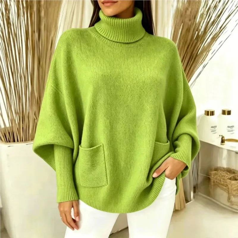 Woman wearing green turtleneck batwing sweater with front pocket