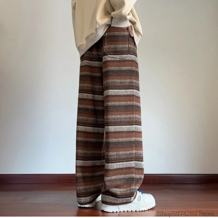 Side view of coffee striped wide leg pants with hand in pocket