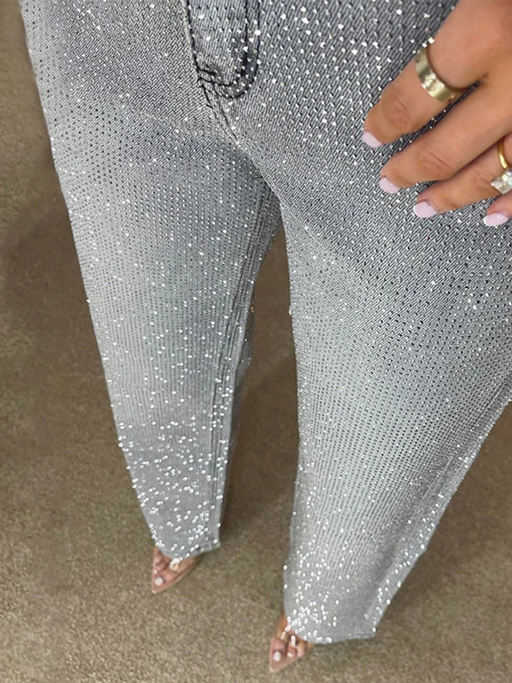 Close up of rhinestone speckled denim texture on light gray wide leg jeans