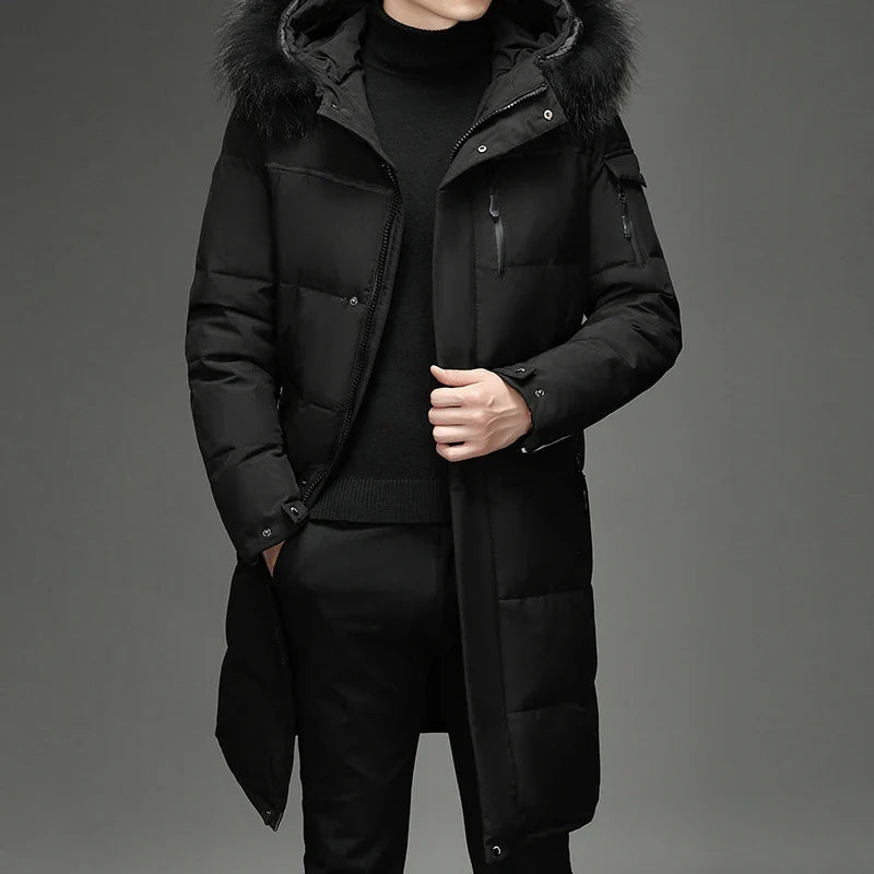 Man wearing black hooded down coat with fur trim, front view with hand in pocket
